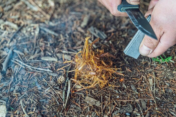 ナイフなどでなるべく薄く削った樹皮を、両手で細かくちぎりながら揉みほぐすと、火口（ほくち）に（『焚き火の教科書』より）