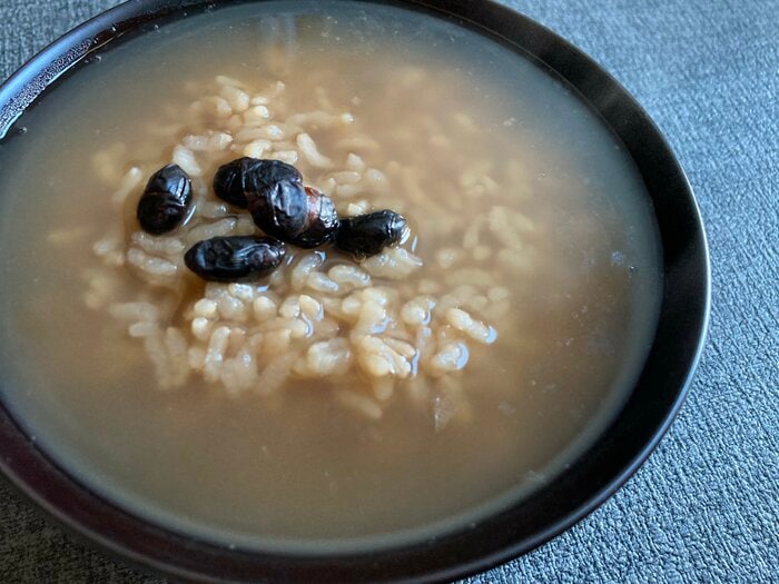 茶粥に炒り黒豆の醤油漬けをのせて
