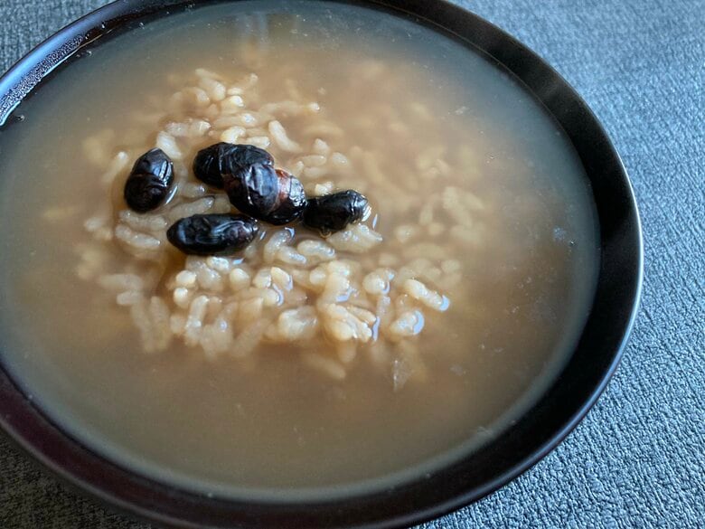 茶粥に炒り黒豆の醤油漬けをのせて