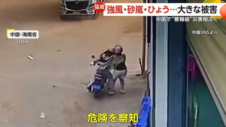 目の前の建物が倒壊し慌てて逃げる人（10日、中国・海南省）