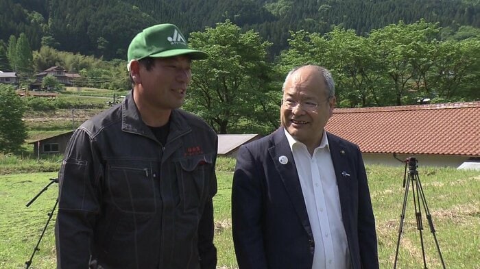 田園風景の中で談笑する橋本和則さん(左)と雲南市・石飛市長(右)