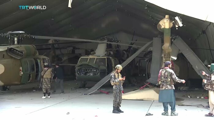 壊された米軍のヘリコプターを調査するタリバン戦闘員ら(カブール 2021年8月31日)