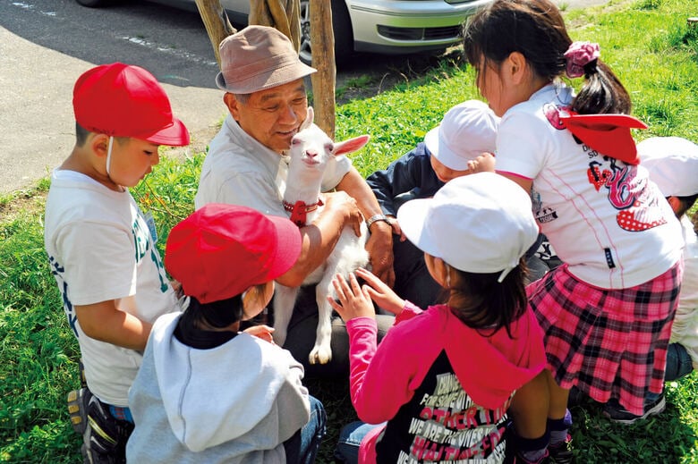 子ヤギに群がる子供たち。これから1年間、みんなでヤギを育てていく（『ヤギと暮らす』より）