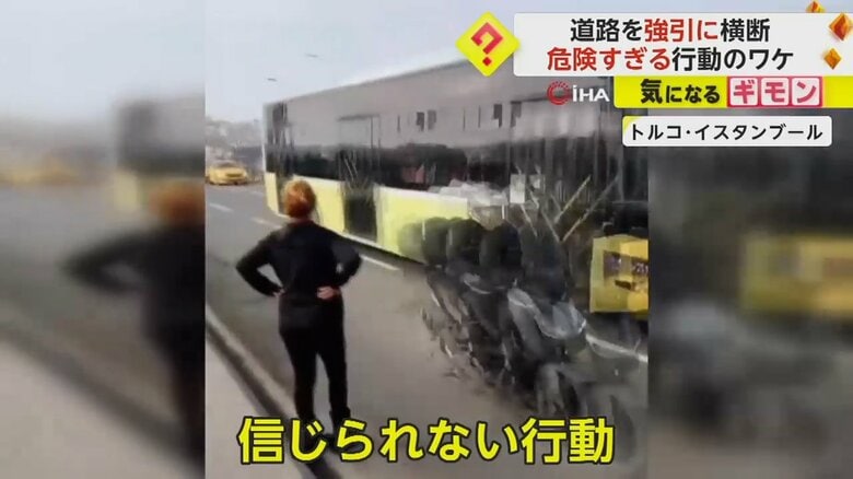 トルコ・イスタンブールの道路で目の前を行き交う車を見ている女性