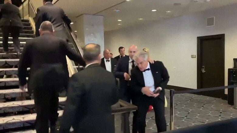 会場から避難する出席者たち