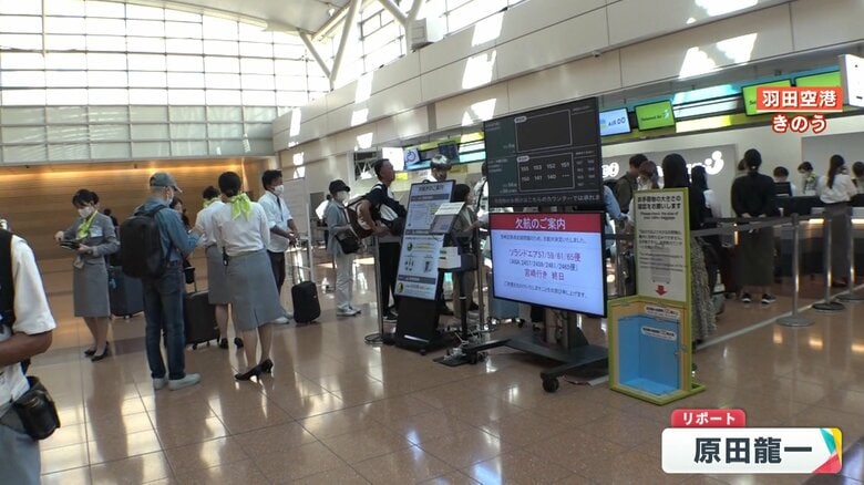 羽田空港　欠便の案内を受けカウンターに並ぶ人々