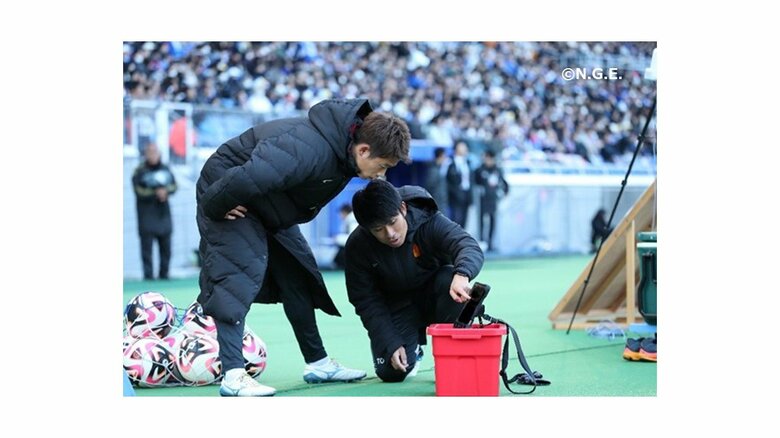 試合中に控え選手と情報を共有する山田氏