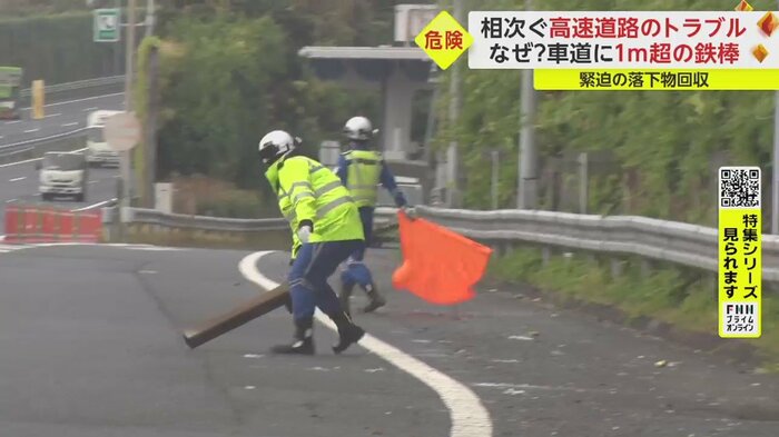 車の流れが途切れる一瞬の隙を見計らい、落下物を回収する隊員。
