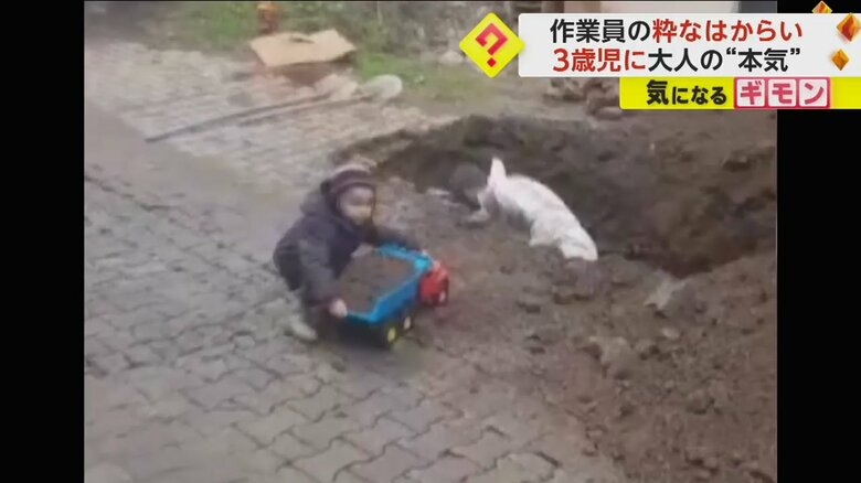 砂の入ったトラックに手を伸ばす男の子