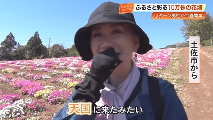 花畑を散策し、笑顔を見せる女性来園者