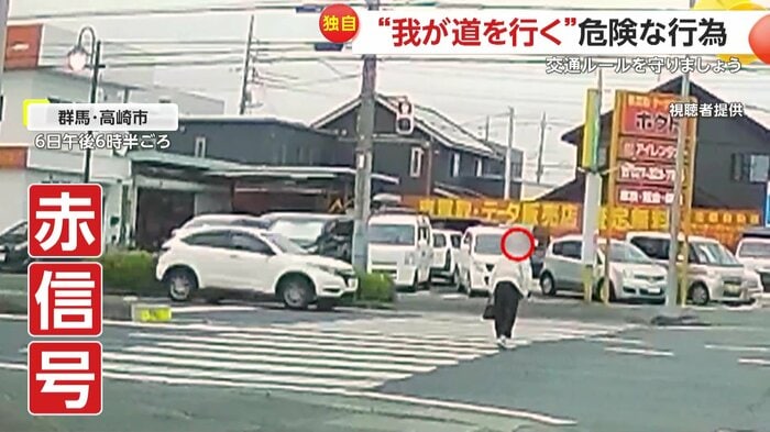 車が行き交う中を突き進む女性