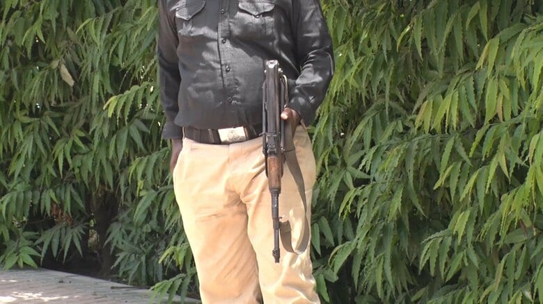 銃を持った警備らしき男性が、周囲を警戒している