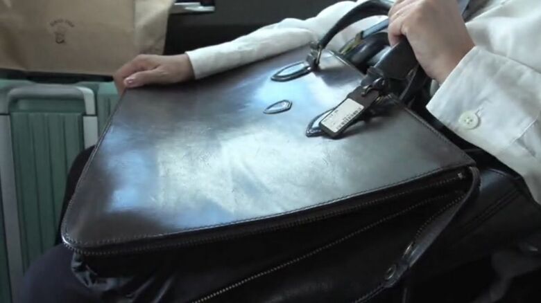 赤木さんのカバンを持って取材に応じる妻・雅子さん