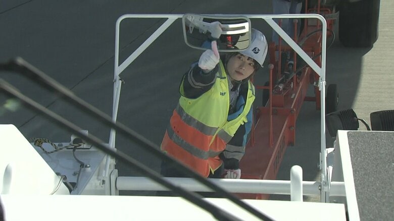 連結棒で飛行機とトラクターをつないだ合図を送る岡山さん