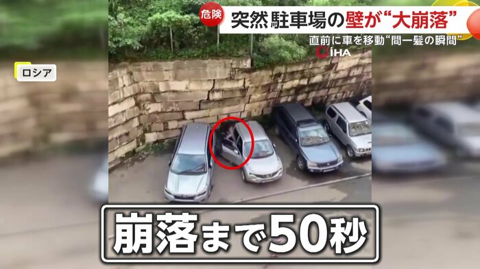 ゆがんだ壁を後ろに車を動かす男性