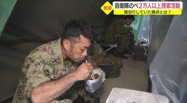 集結所で食事をとる隊員