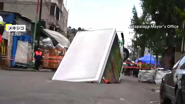 トラックが大きな音を立て、穴の中に落下する瞬間（13日、メキシコ・メキシコシティ）①