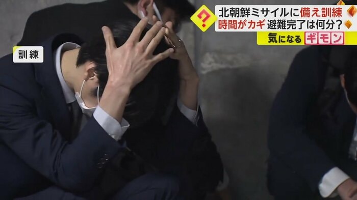 低い姿勢で頭を抱え、身を守る職員