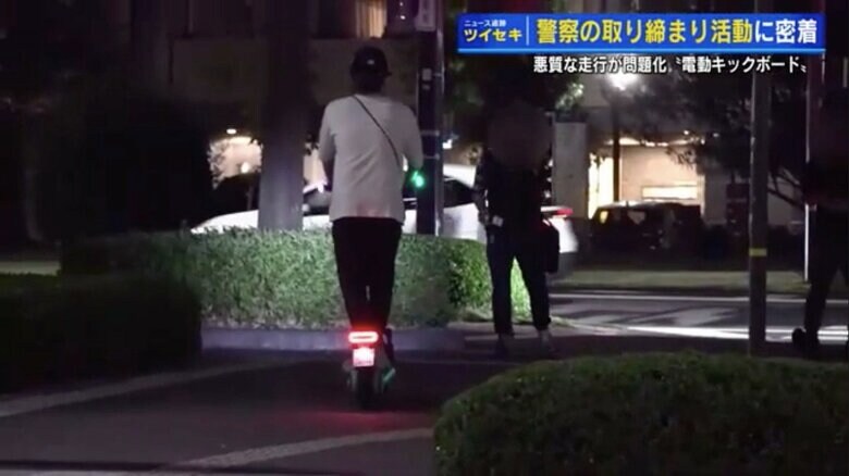私服警察官に止められる電動キックボードの男性
