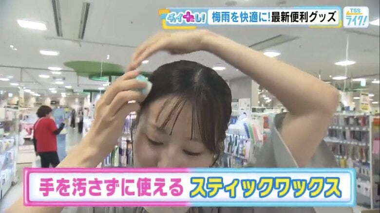 髪に直接あて、湿気で広がった髪を整える中西アナ