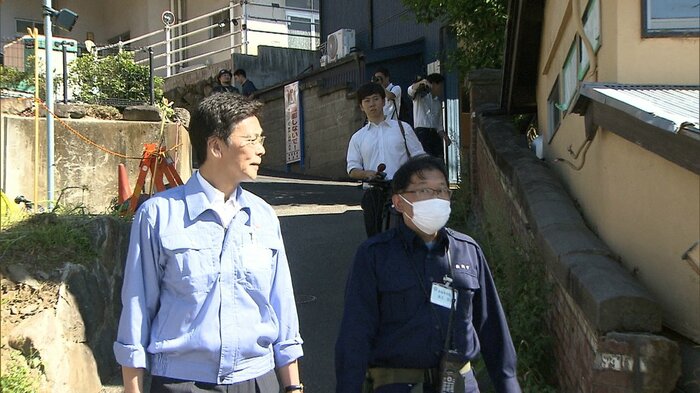 警戒区域解除後に視察する斎藤市長(左)
