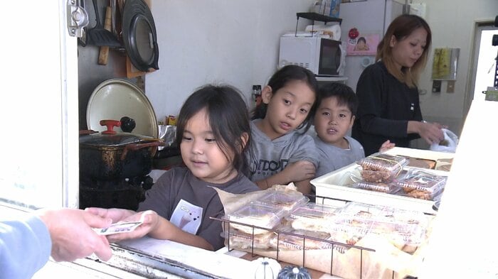 お母さんと一緒に接客する3人の子供たち