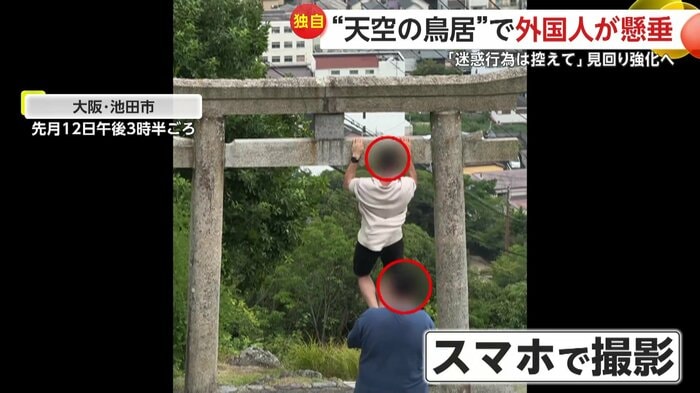 鳥居で懸垂する人物と撮影する人物(Ilya Miskov)