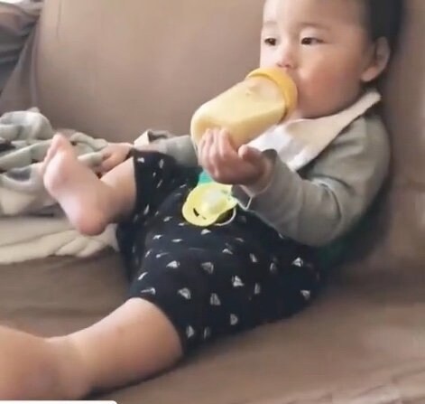 なぜか片足を浮かせてミルクを飲む赤ちゃんの時の次男わくくん(提供:awarireさん)