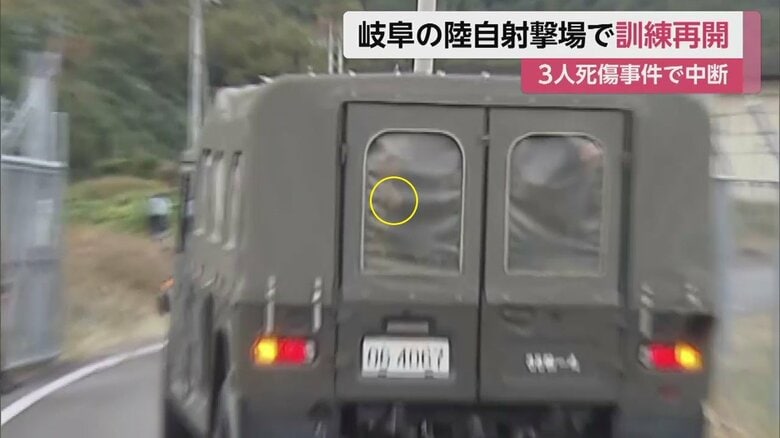 訓練場に入る、隊員を乗せた車両。報道陣の前を通り過ぎる際、中指を立てるようなしぐさ（6日午前7時ごろ）