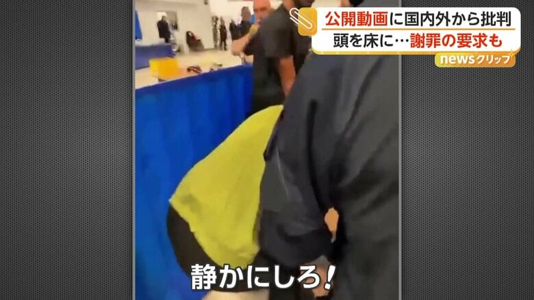 「静かにしろ！」と怒鳴り、手をあげる警備員