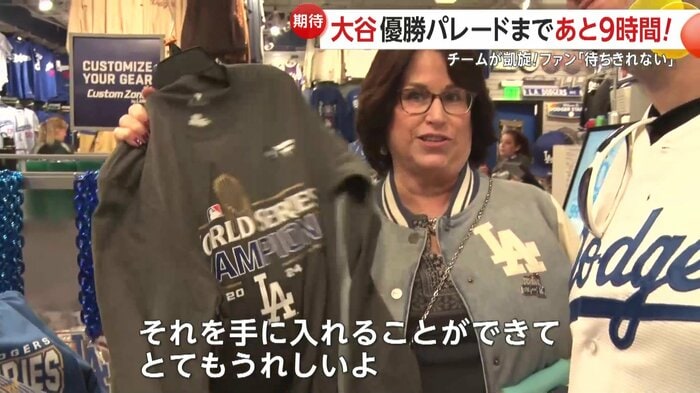 グッズショップで記念グッズを買い求めるファン