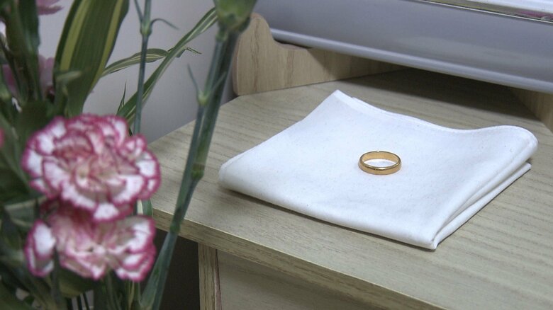 昌弘さんの遺影と遺骨の前には結婚指輪が