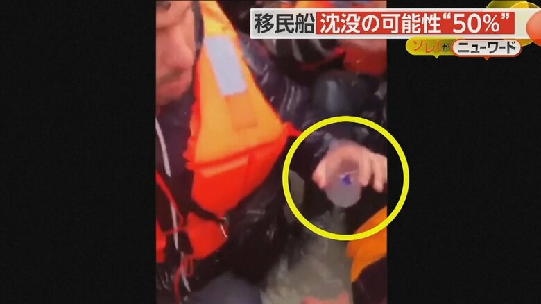 小さなコップを手に船に溜まった水をかき出そうとしている移民たち