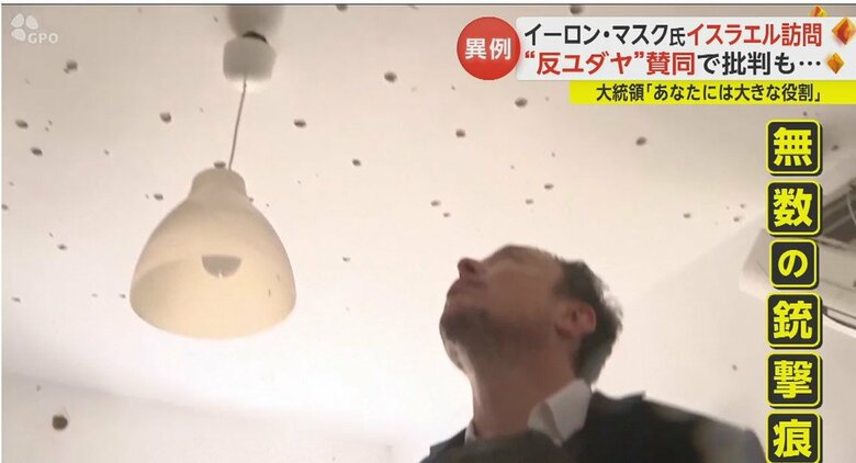 天井に残された無数の銃撃痕を見つめるマスク氏