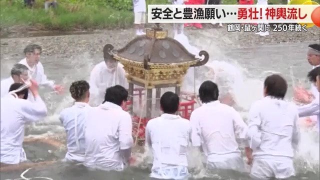弁天様がまつられたみこしに冷たい川の水をかけ清める