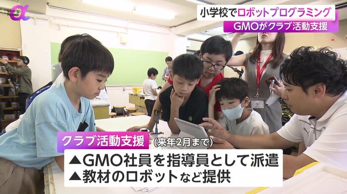 タブレットでロボットを操作する児童ら