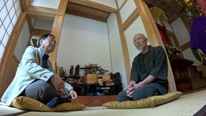 住職から話を聞く金田さん