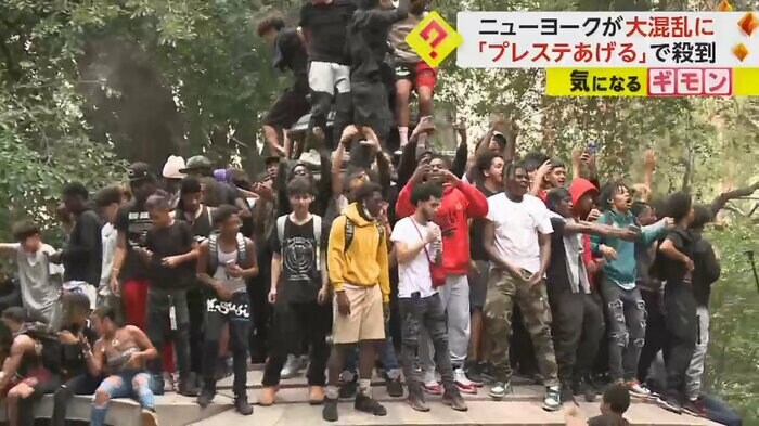 大勢の若者が公園に集まり、手を挙げている
