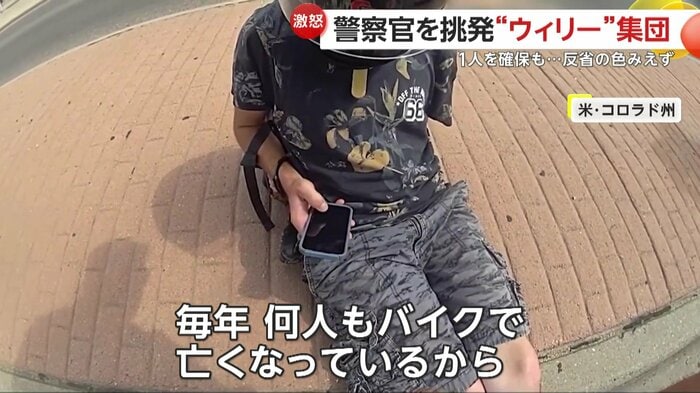 スマホをいじりながら警察官の話を聞くライダー(Pueblo Police Department)