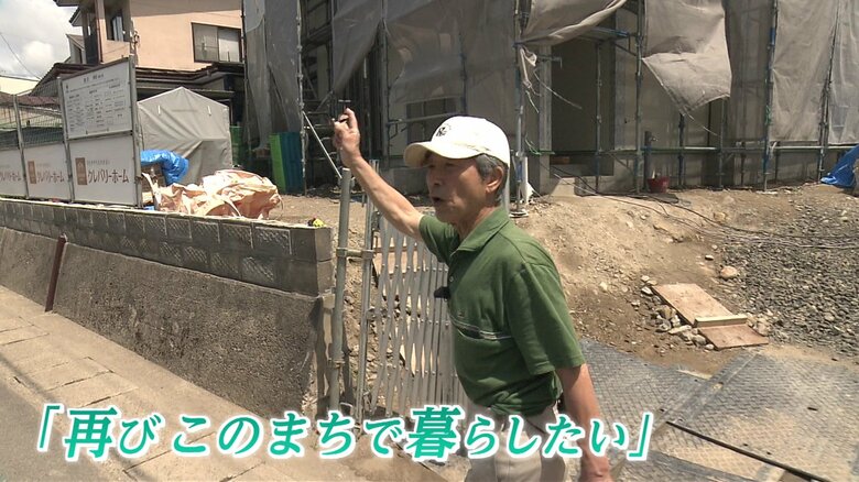 まちを案内する伊藤さん　住宅の修繕工事も進んでいる