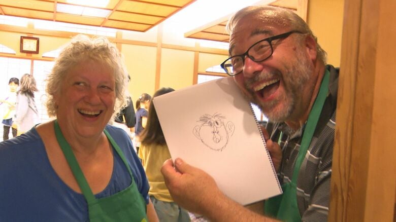 似顔絵をもらって喜ぶ夫妻