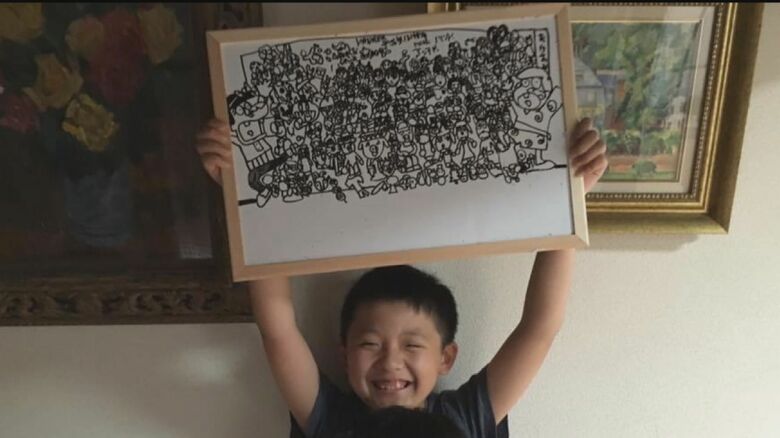 作品を掲げてニコニコ…幼い日の貫太さん