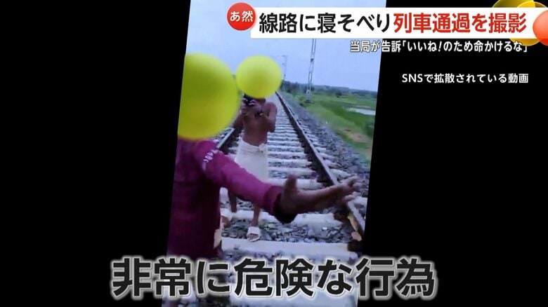 駅の近くで線路に寝そべる少年を友人が撮影