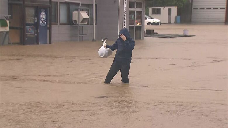 ひざ下まで浸かりながら歩く人