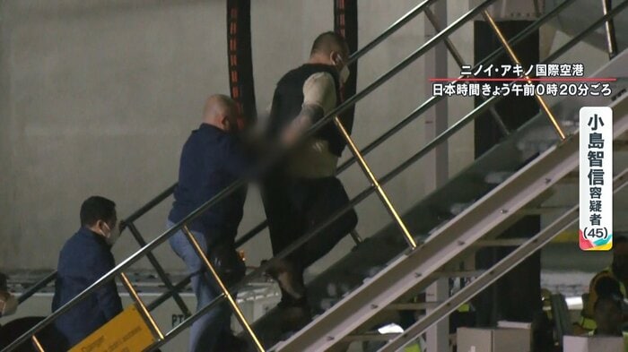 ゆっくりとした足取りで飛行機に乗り込む小島容疑者
