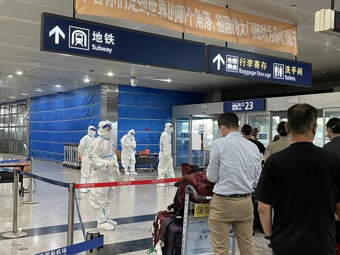 大連空港で待ち受ける防護服姿の係員ら(2022年7月28日)