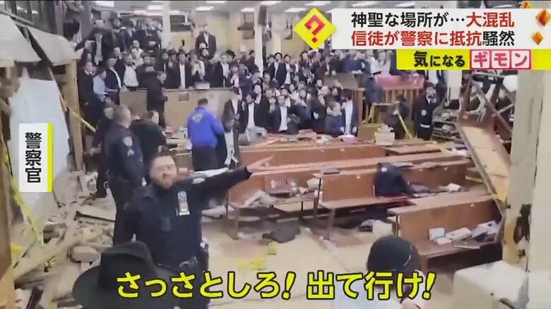 「出て行け！」と信徒に警告する警察官