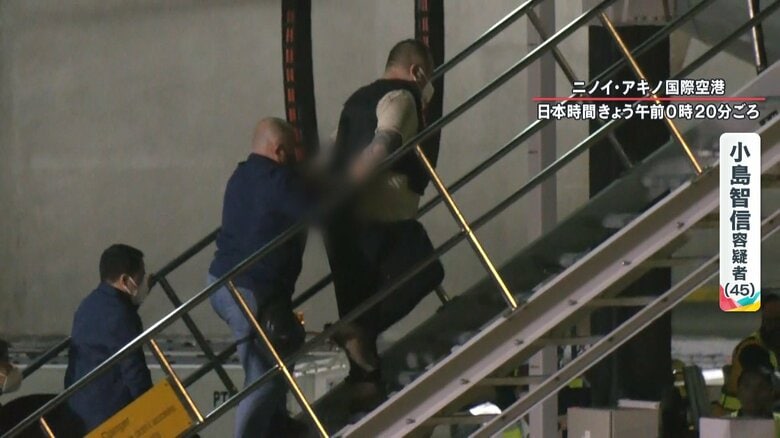 ゆっくりとした足取りで飛行機に乗り込む小島容疑者