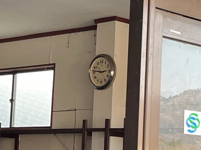 崩れたままの建物の時計は、地震発生時刻を指している