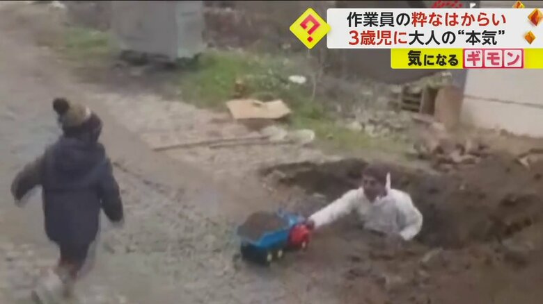 おもちゃのトラックを男の子に手渡す工事現場の作業員